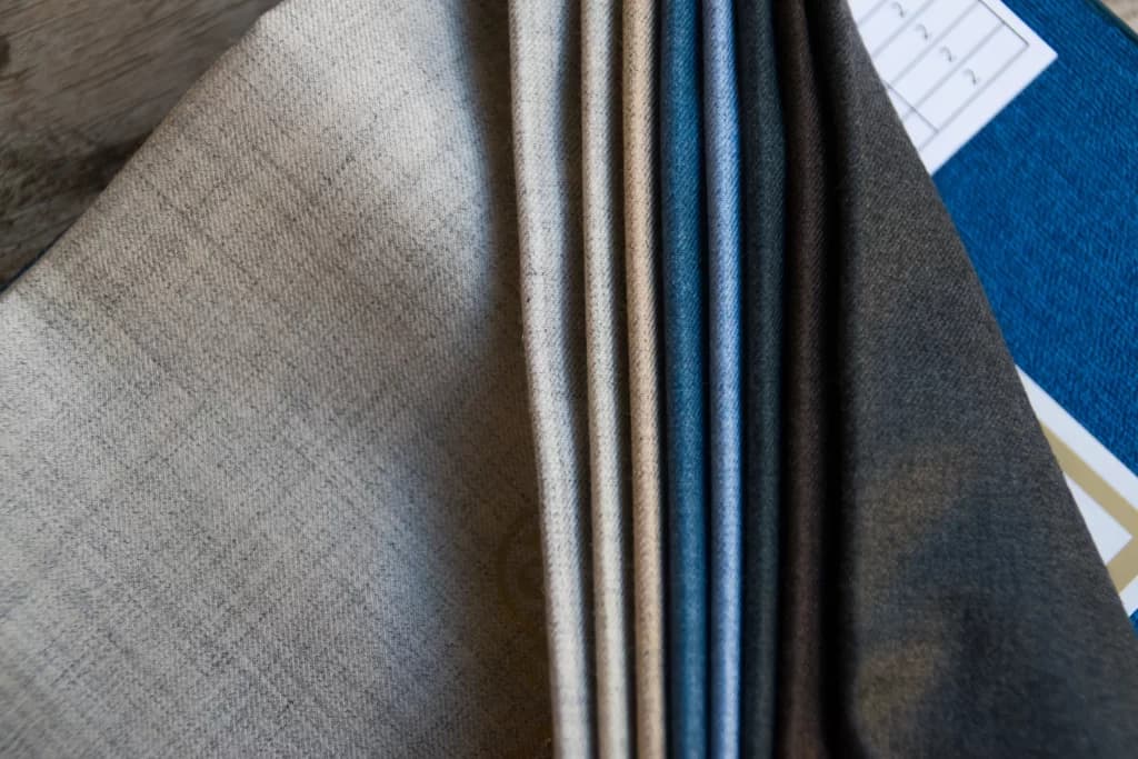 Suiting swatches in grey, blue, and brown at Khimji's